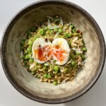 Pea Pesto Ramen in a brown bowl with a jammy egg.