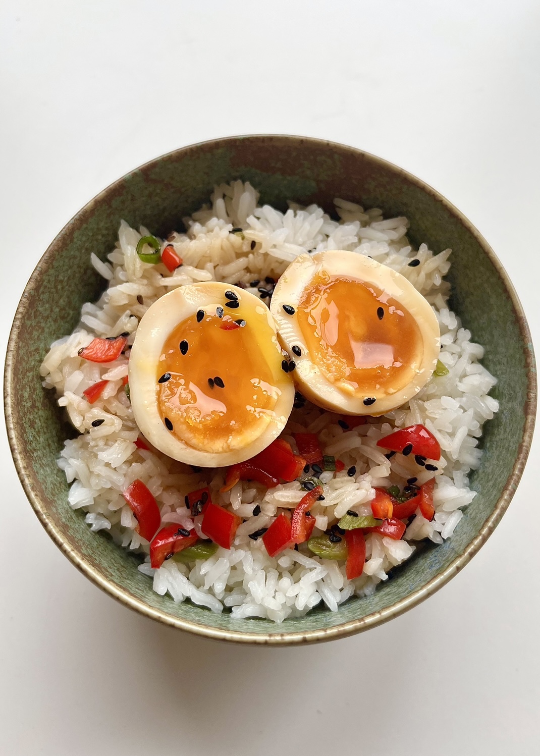 Miso marinated egg sliced open to show the yolk on a bed of rice.