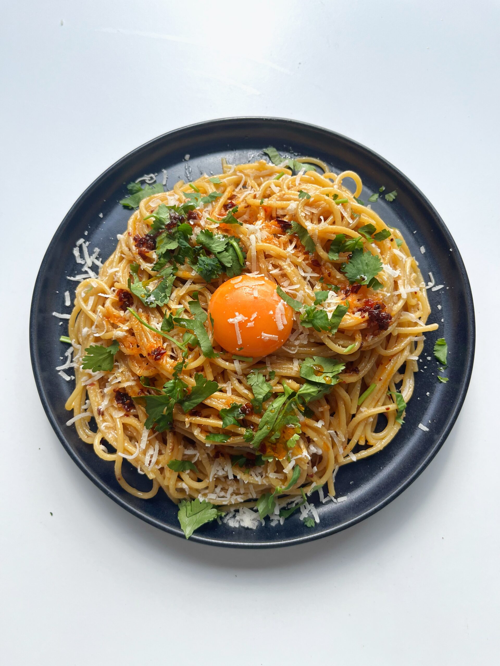 Tahini Chilli Oil Spaghetti with egg yolk on black plate