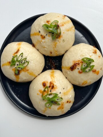 coconut bao (steamed buns) topped with spring onion and chilli oil.