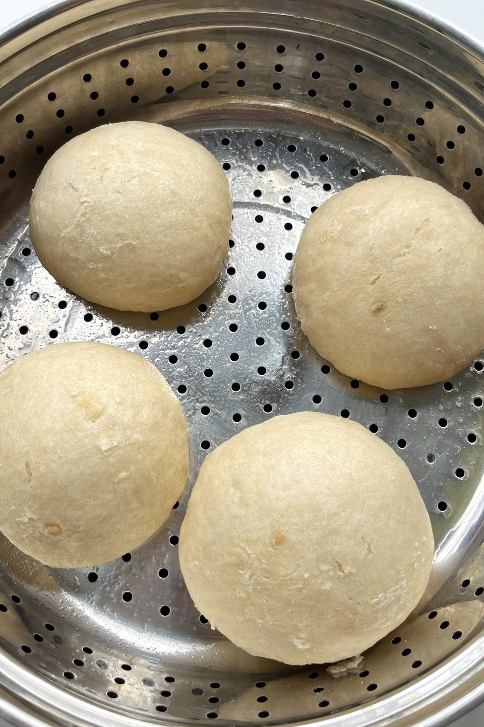 Steaming bao buns in a steamer.