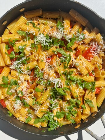 Pollo picante pasta topped with parsley and parmesan cheese.