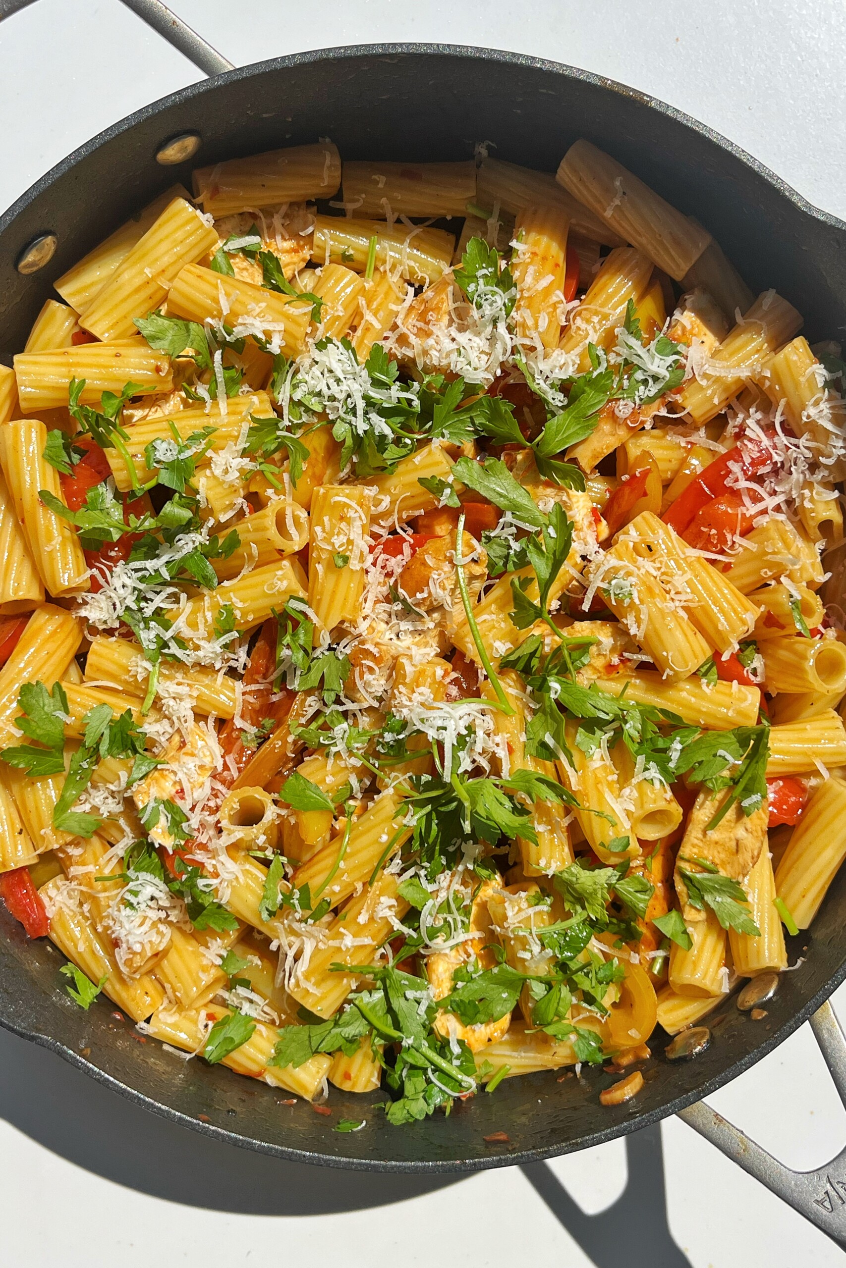 Pollo picante pasta topped with parsley and parmesan cheese.