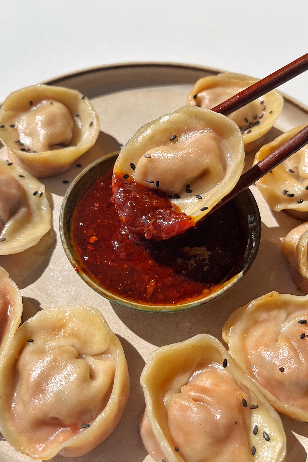 Dipping a Korean style dumpling into a dipping sauce.