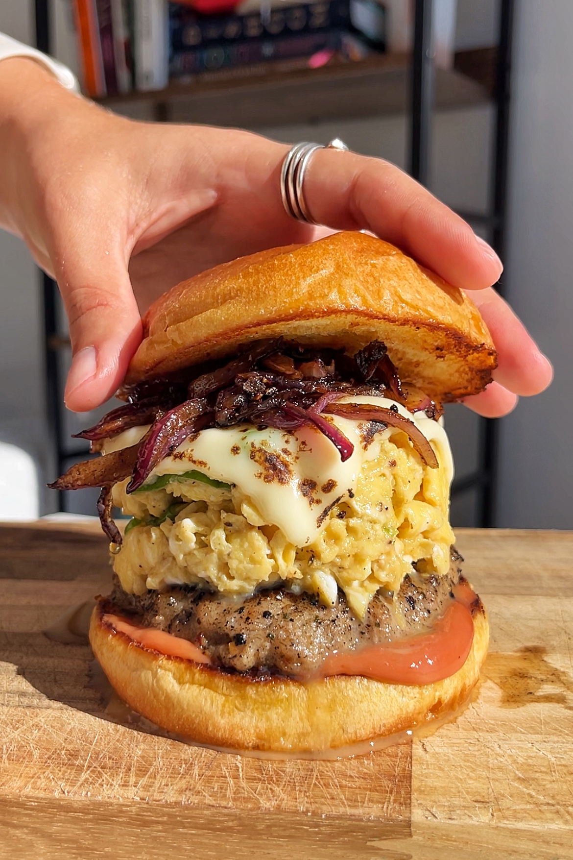 Placing the top bun onto the burger.