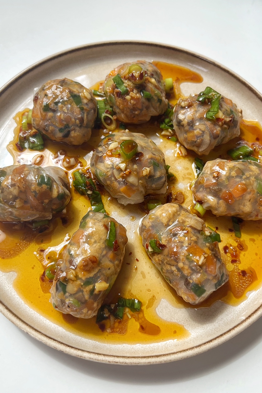 Steamed rice paper dumplings on a cream plate.