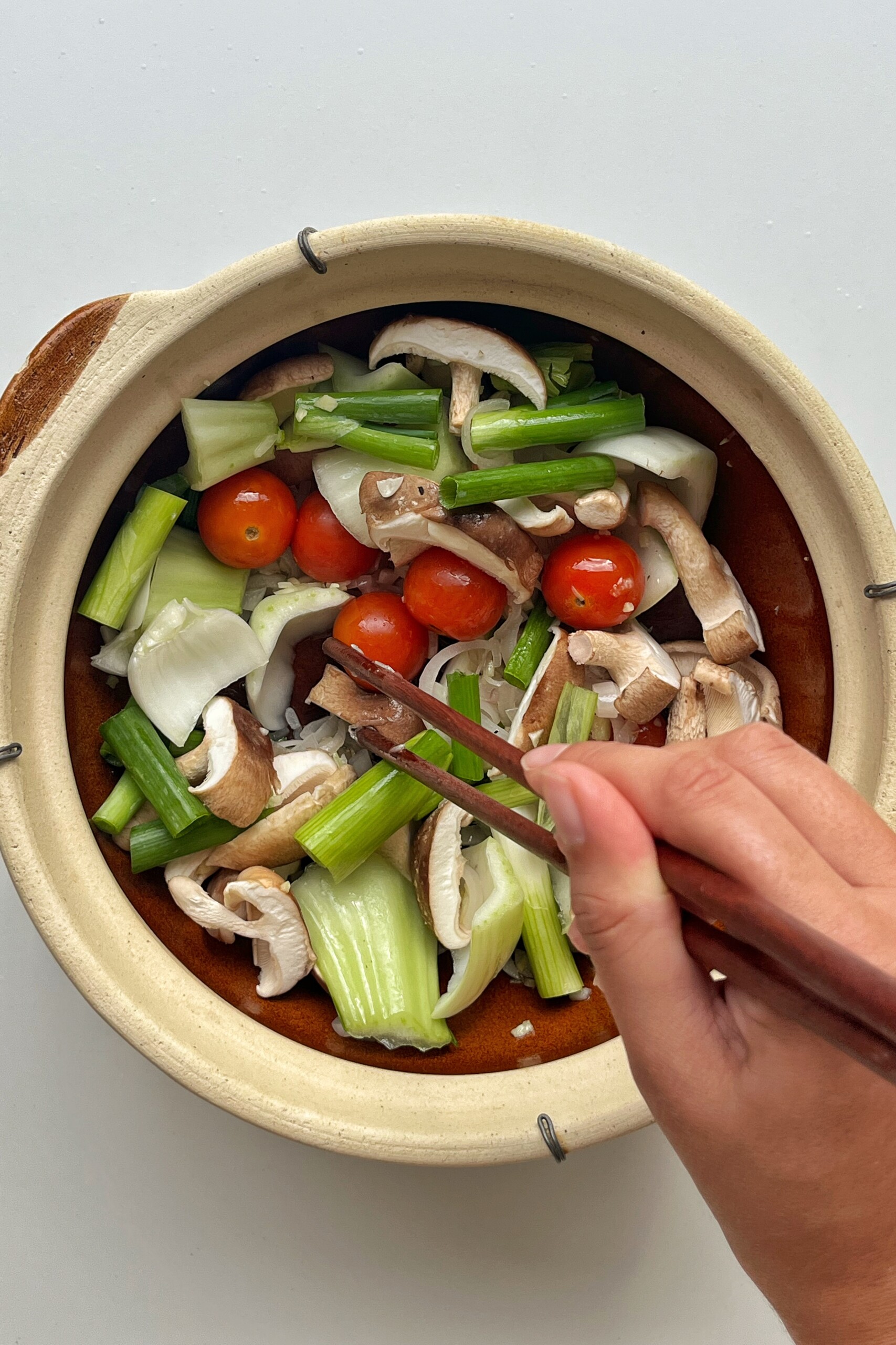 Frying vegetables in claypot.