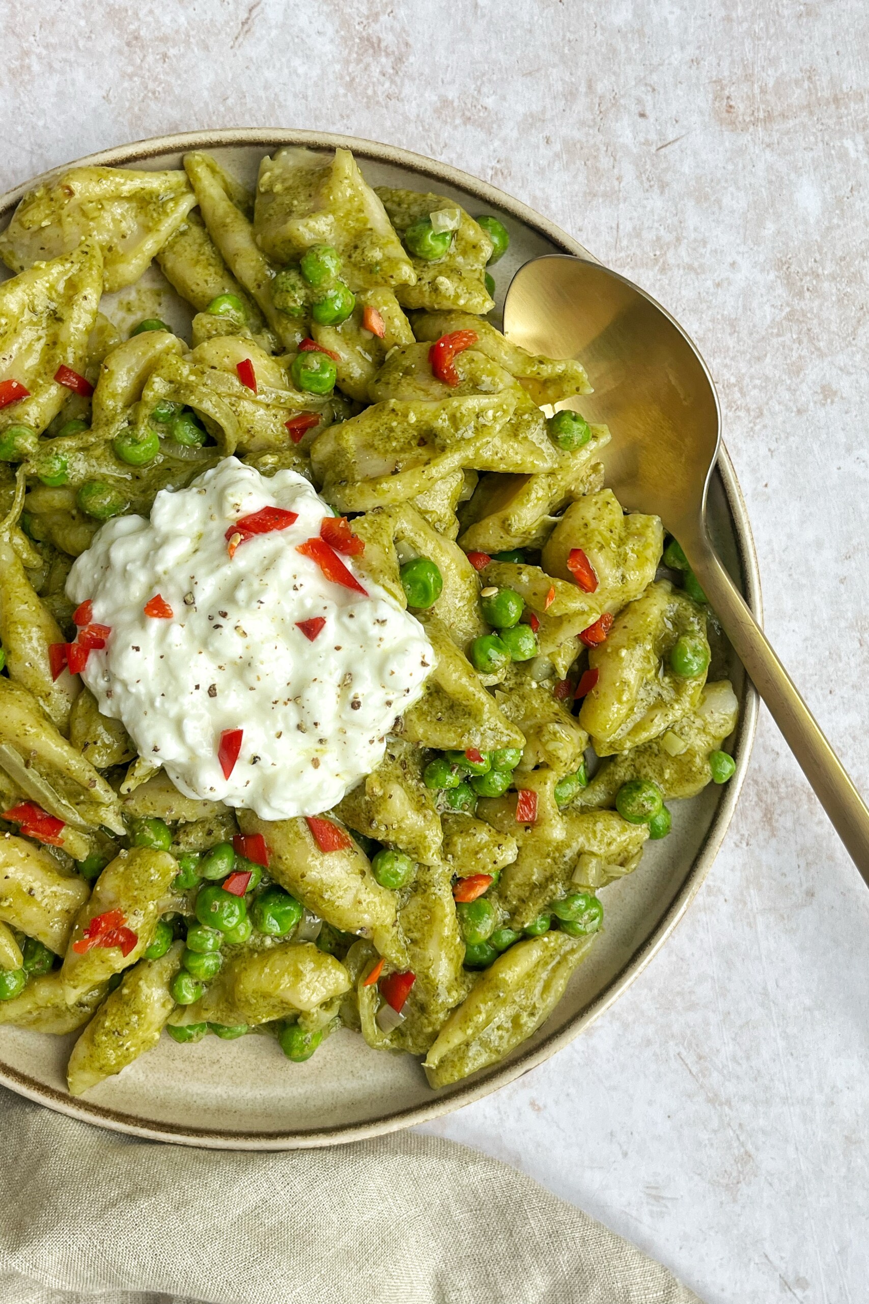 Green pasta on a cream background.