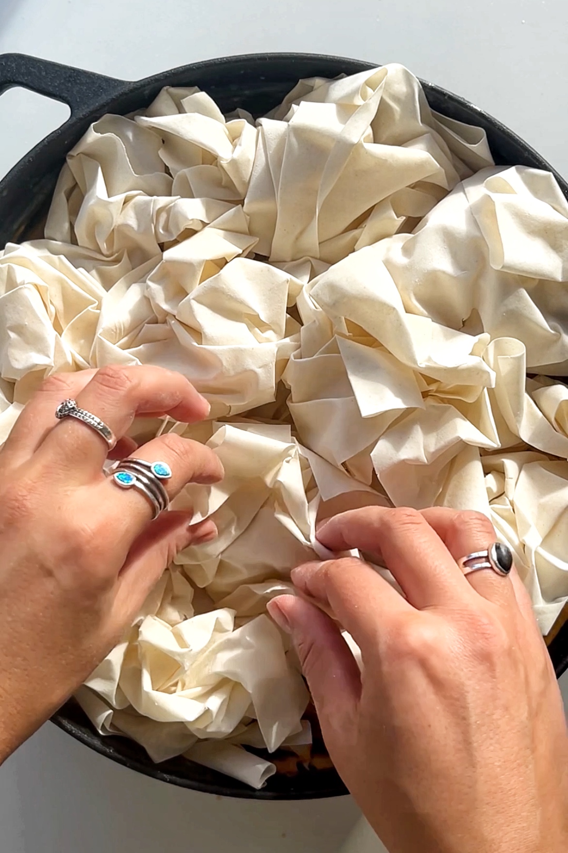 Placing crumpled filo pastry onto of marry me chicken pie mixture.