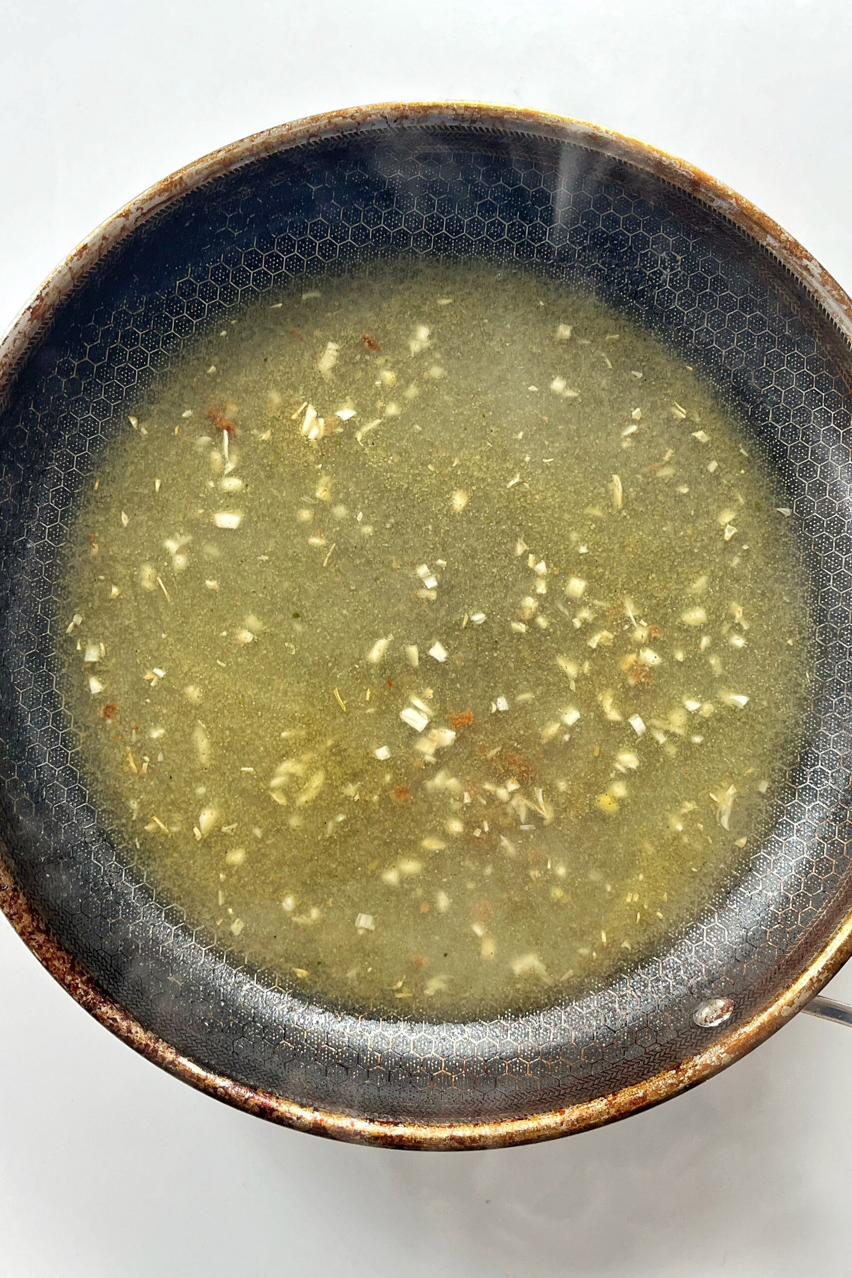 Deglazing the pan with chicken stock.