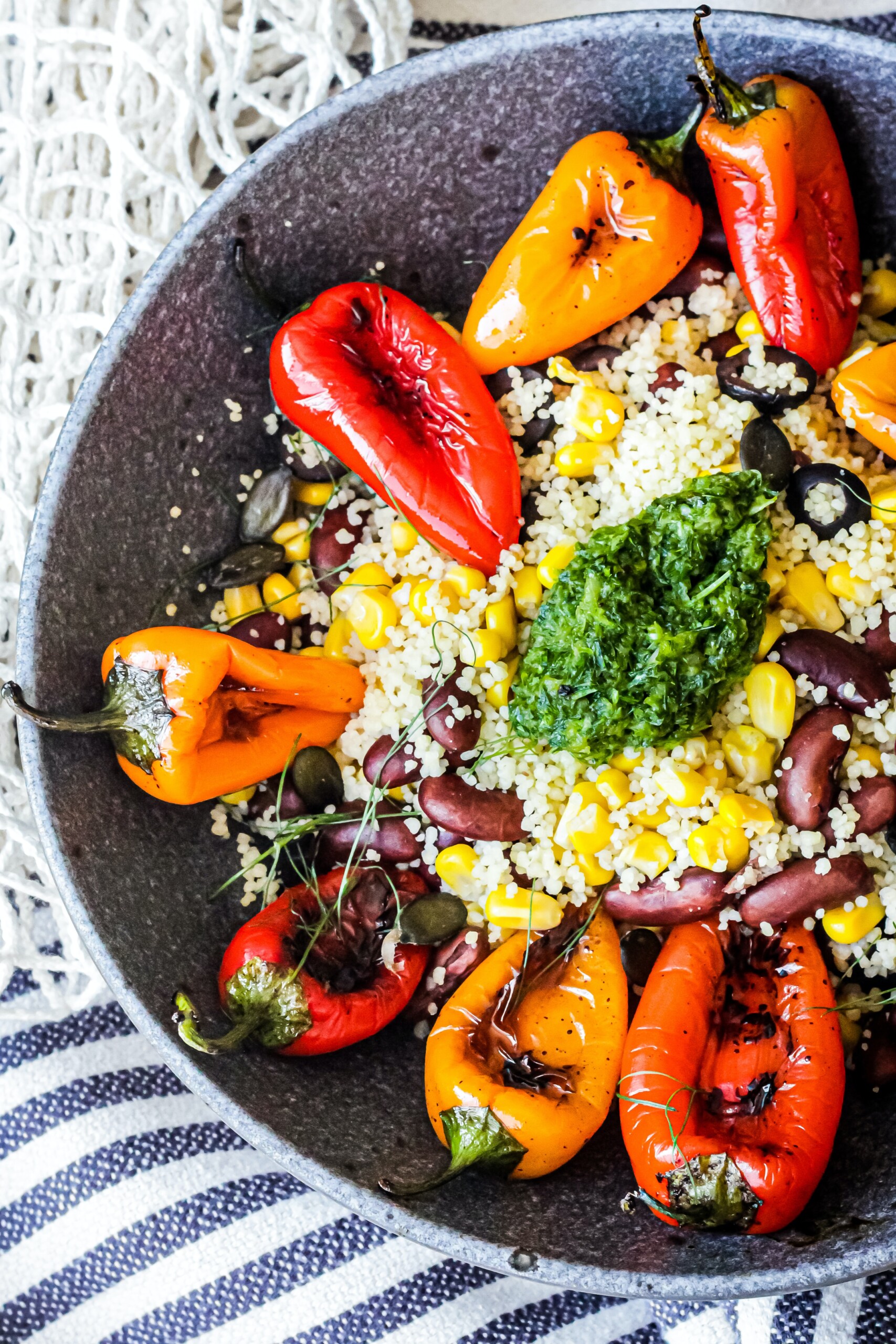 Plate of couscous with red and yellow peppers.