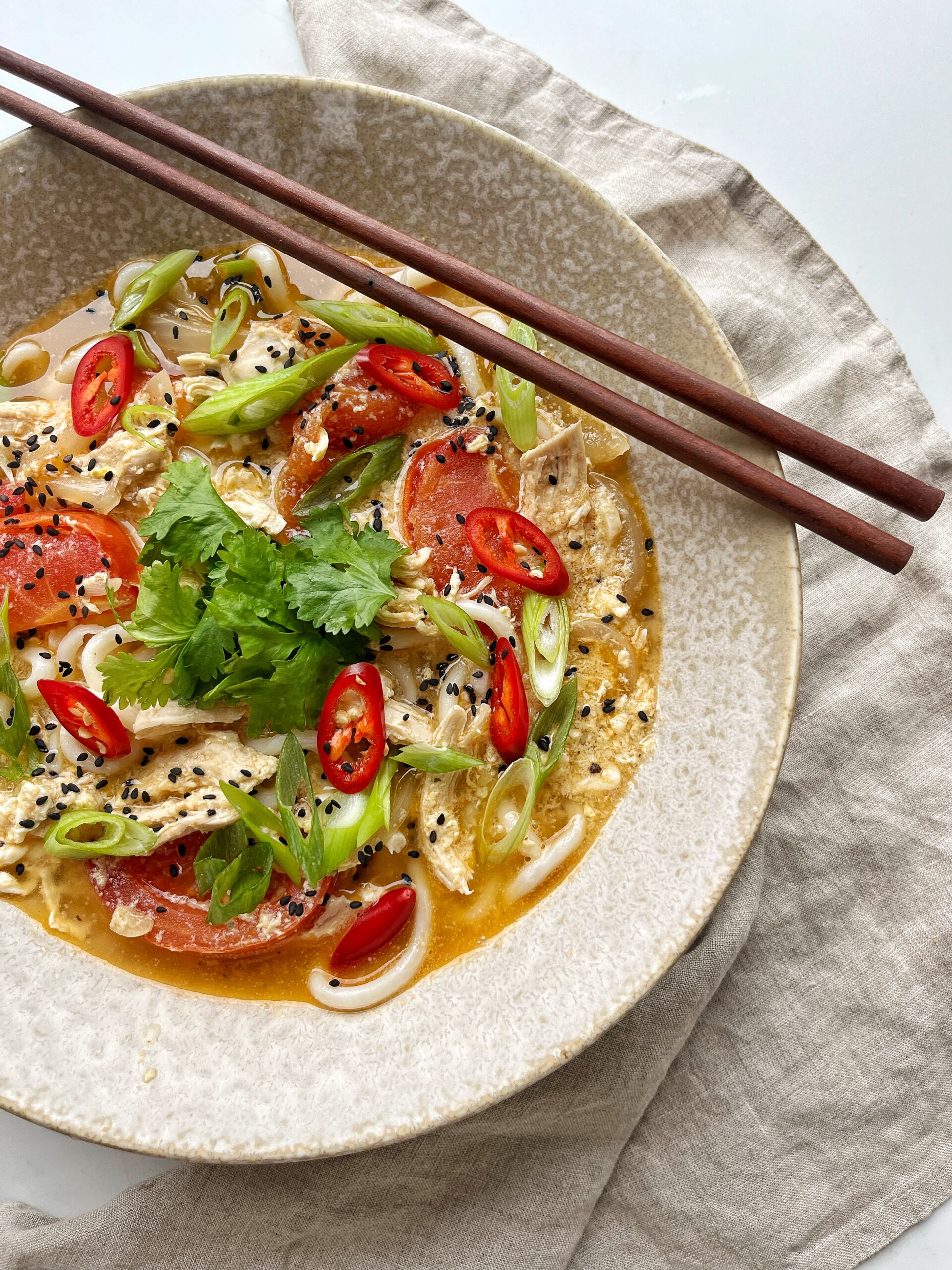 Chopsticks on a bowl of chicken teriyaki udon.