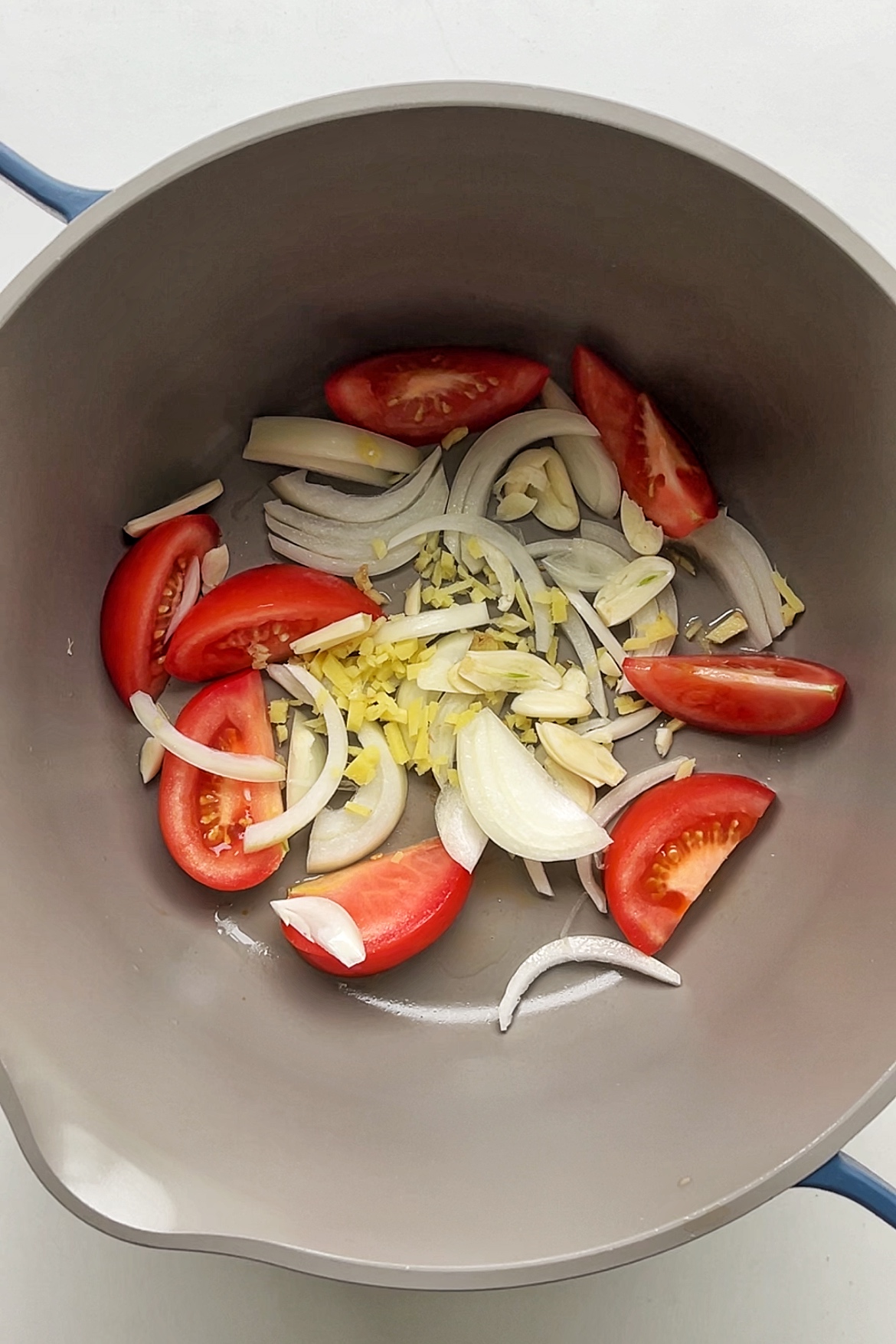 Frying tomato, onion, garlic, and ginger.