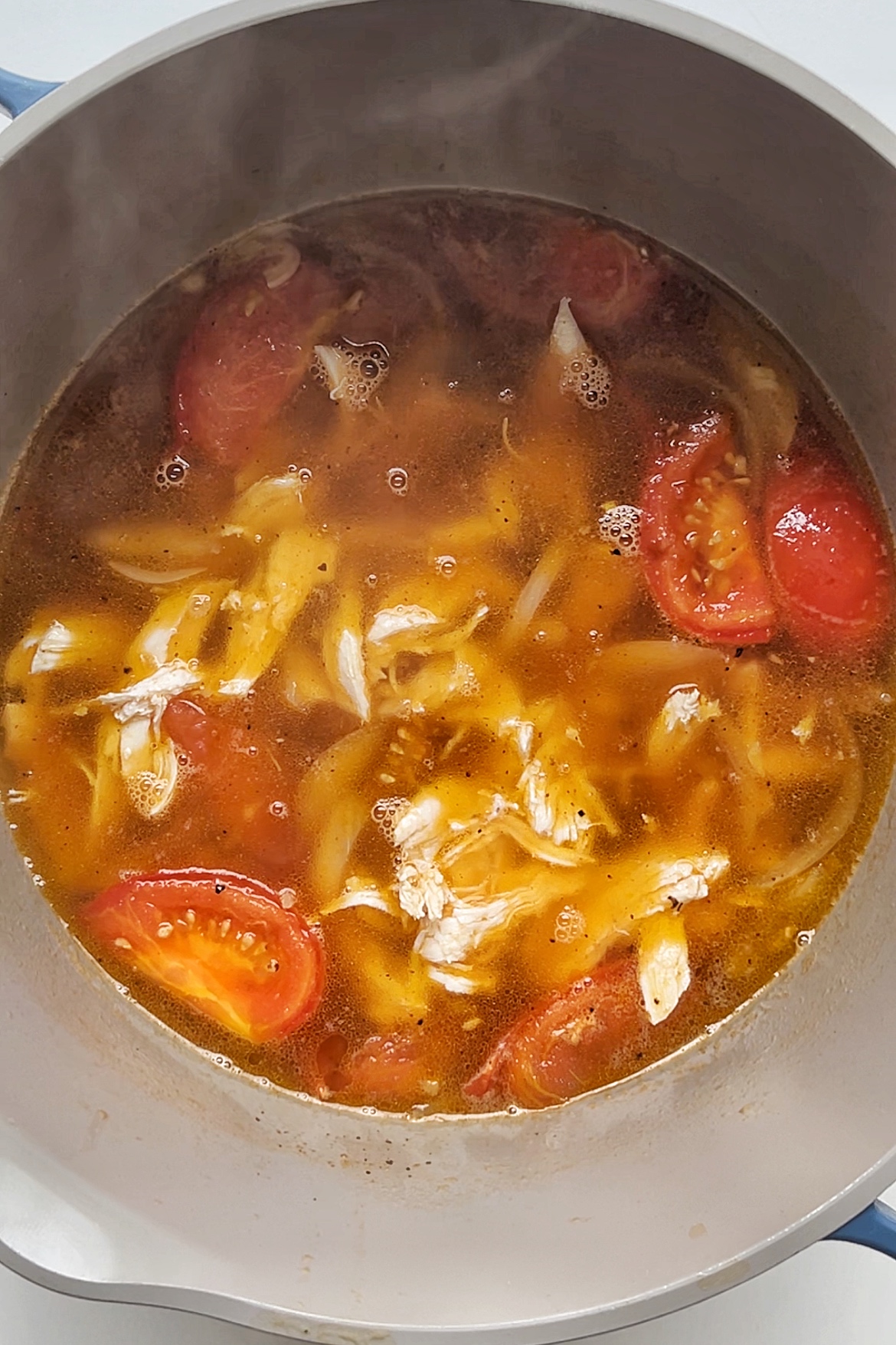 Chicken soup with tomato and seasonings.