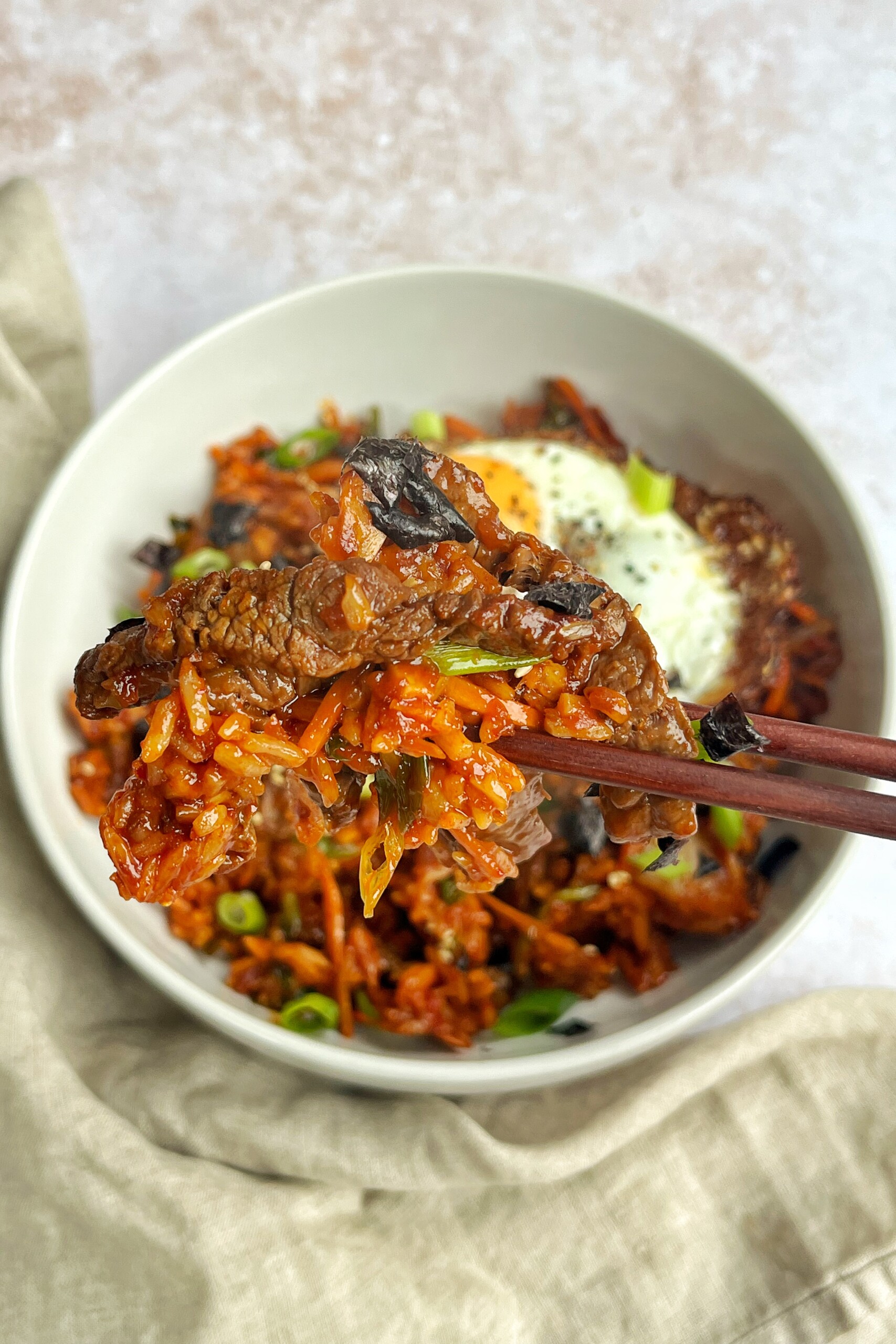 Picking up bulgogi-style fried rice with chopsticks.
