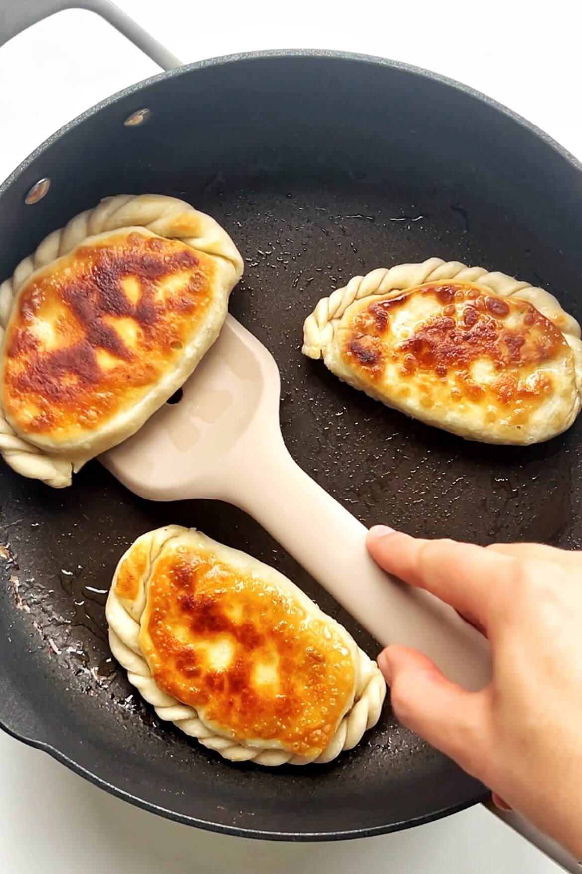 Frying chive pockets in frying pan.