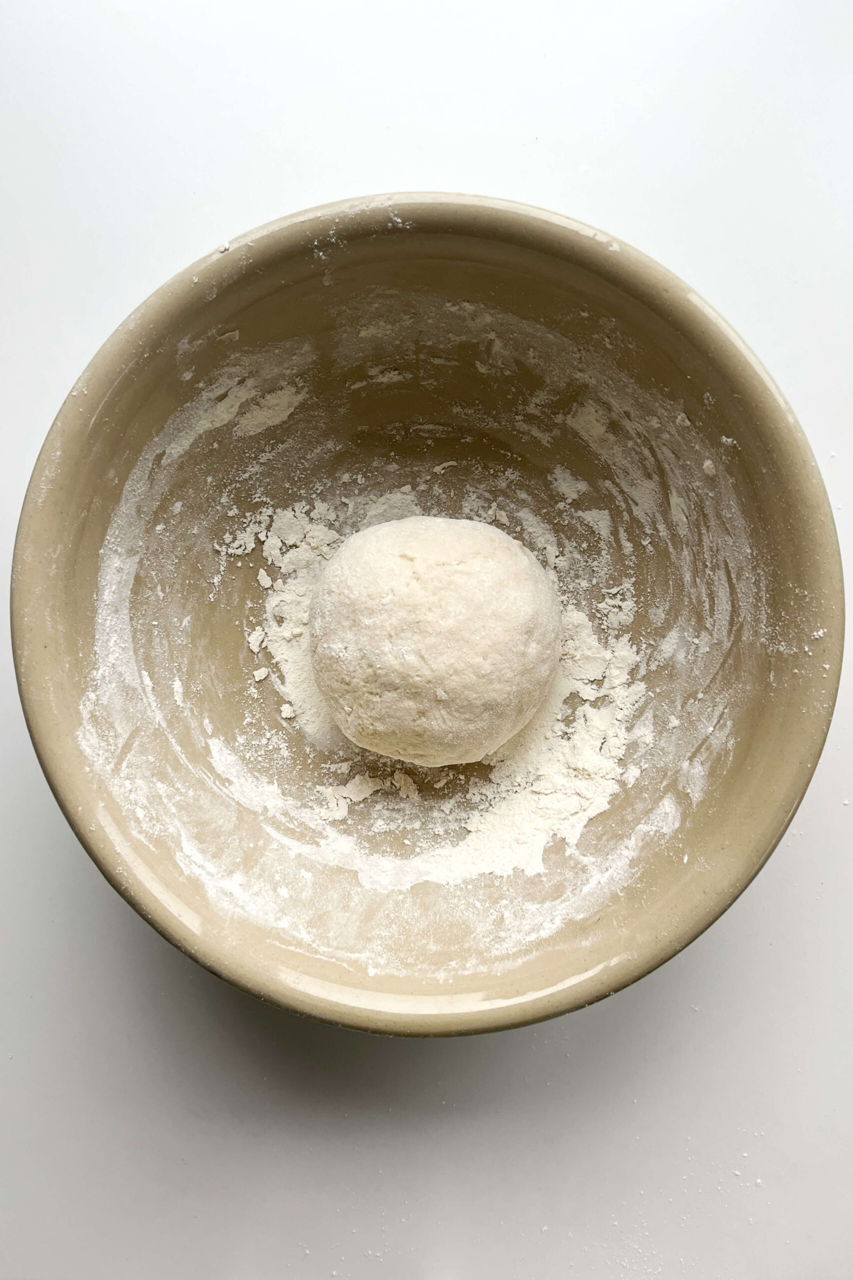 Ball of dough in cream bowl.