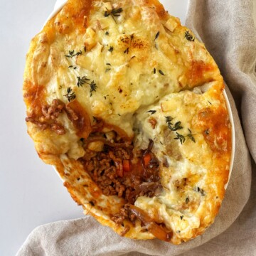 French onion cottage pie with chunk taken out of it.