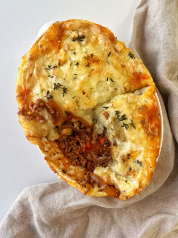 French onion cottage pie with chunk taken out of it.