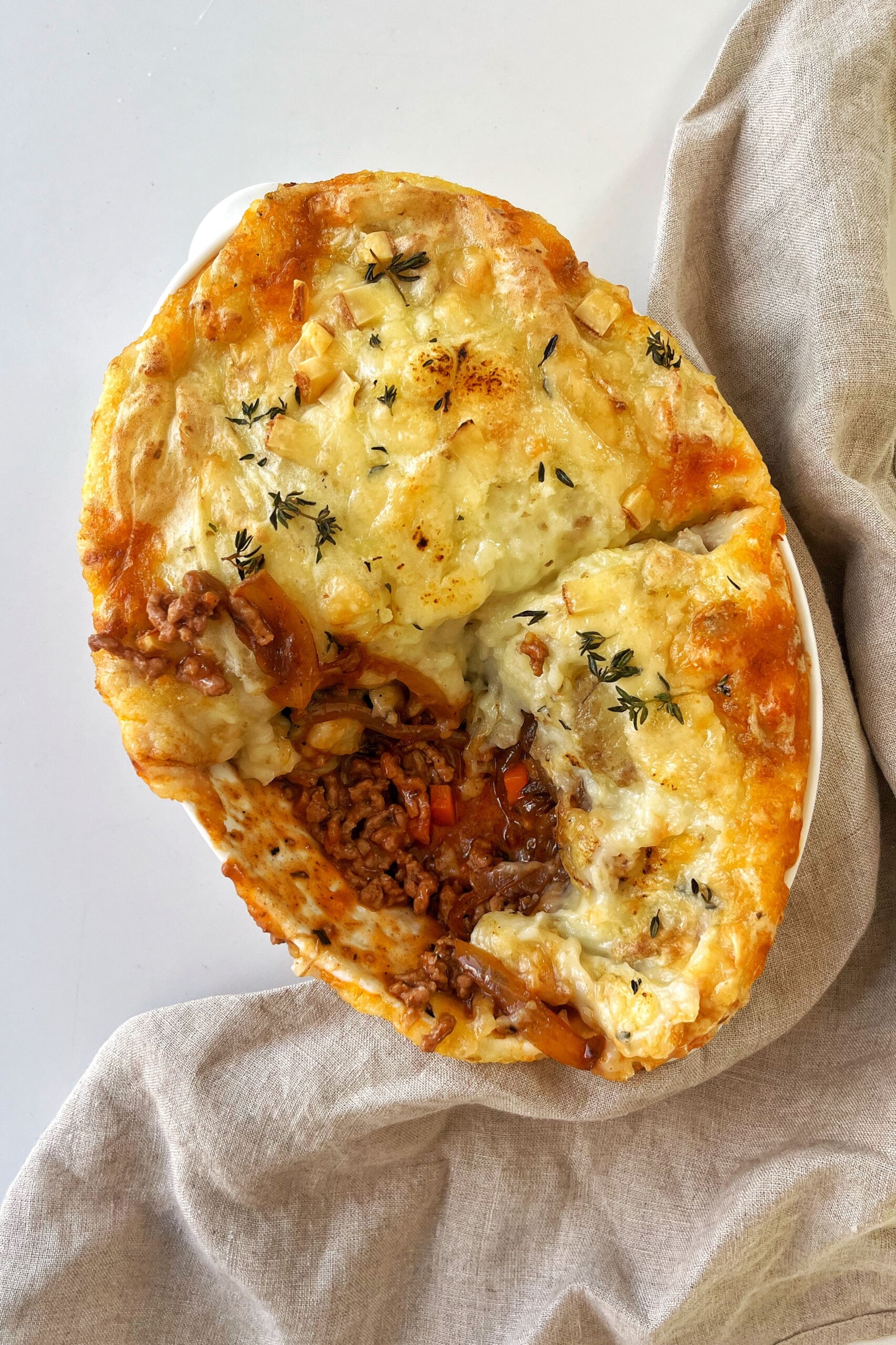 French onion cottage pie with chunk taken out of it. 