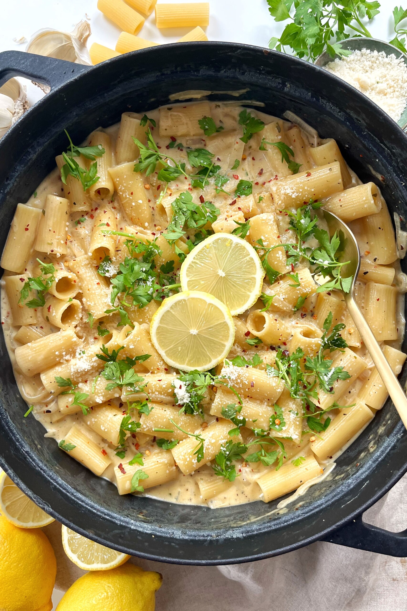 Black cast iron pan with lemon Boursin pasta inside topped with lemon slices. 