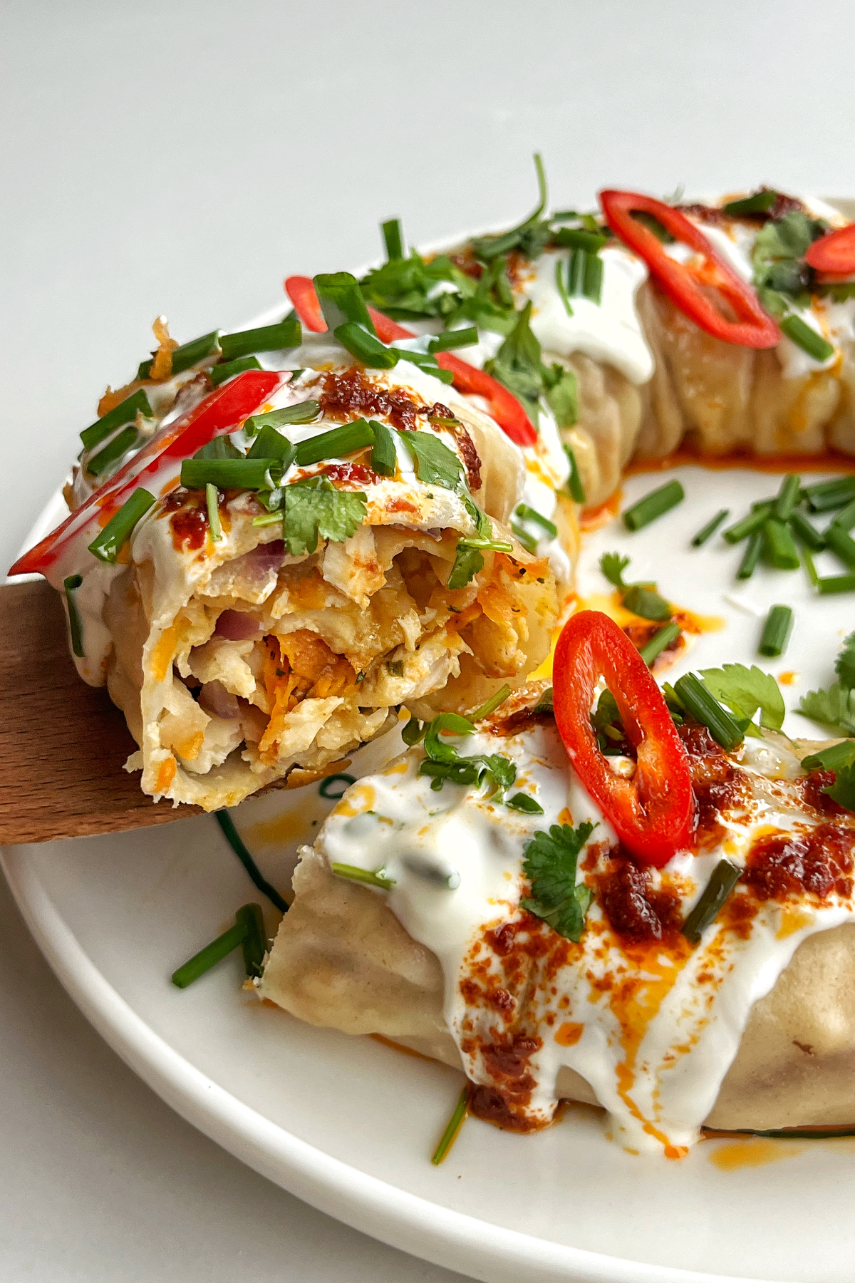 A slice of the dumpling wreath topped with chillies and coriander and yoghurt.