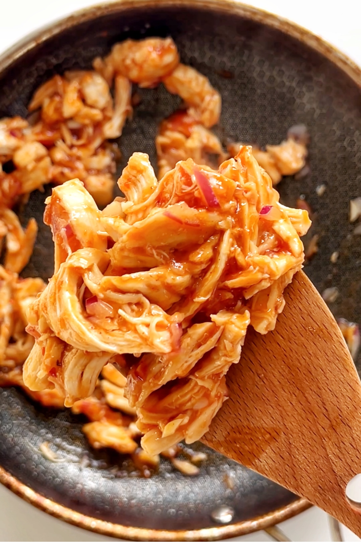 Fried leftover turkey in a sweet chilli jam sauce picked up by a spatula.