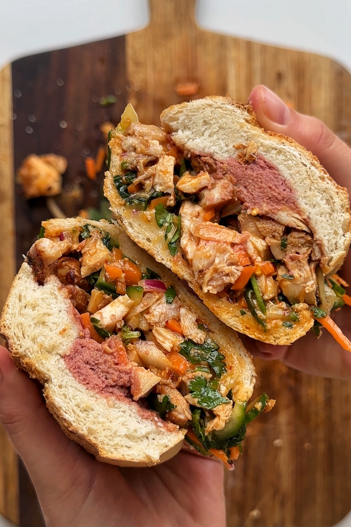 Opened up sandwich with pate, chicken, herbs,  and pickles.