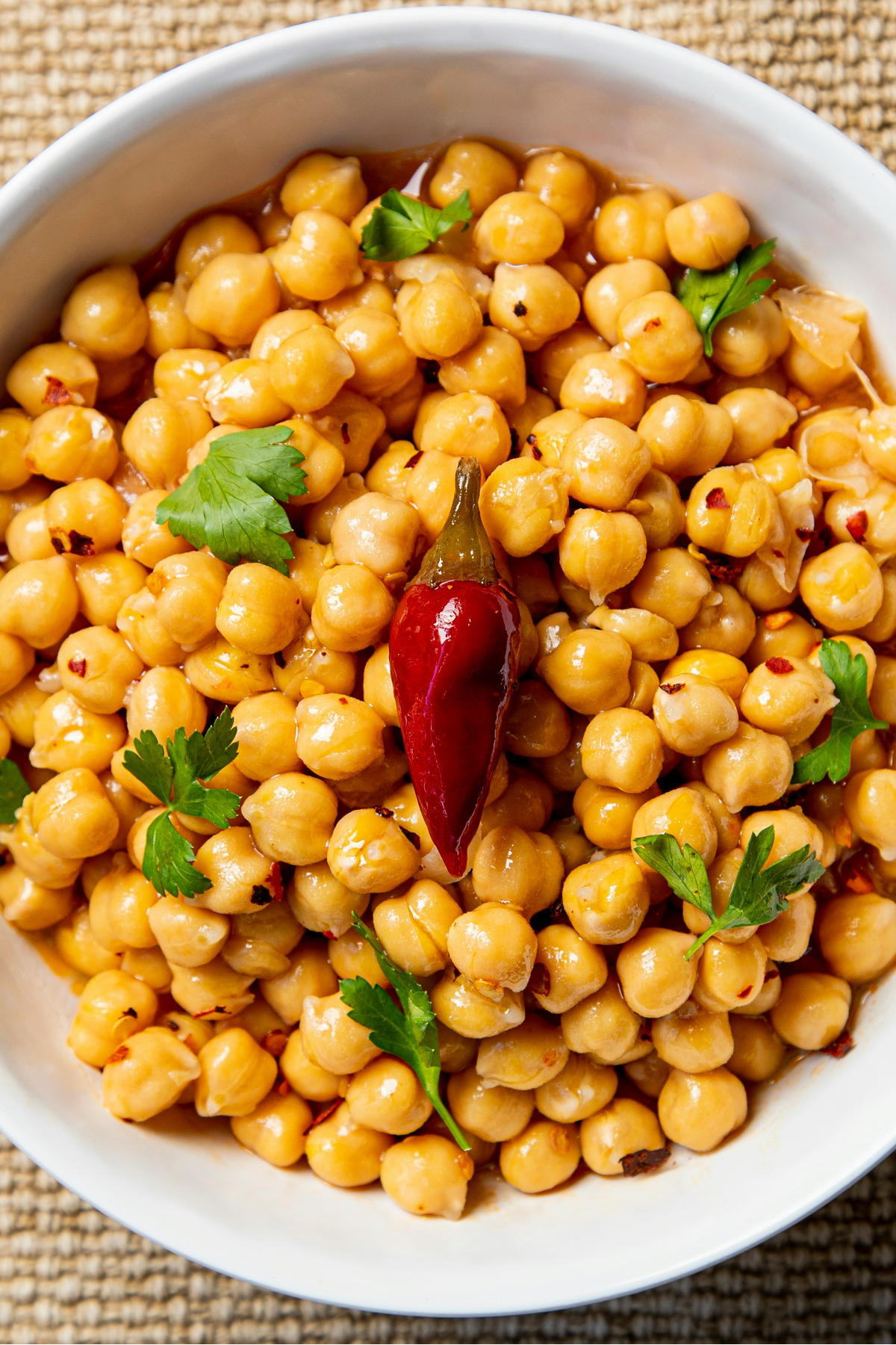 Chickpeas in a bowl with a chilli in the centre placed on top.