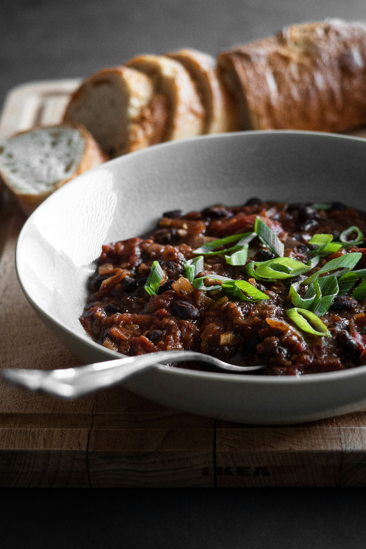 Black bean stew in a white bowl with spoon.