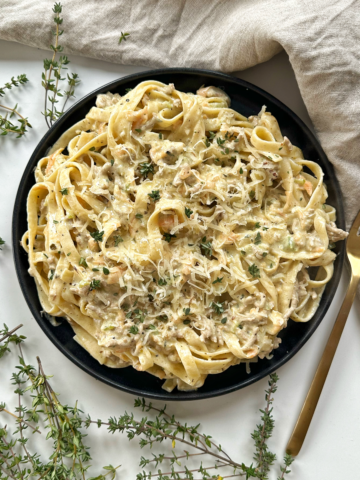 white ragu with tagliatelle on a white background.