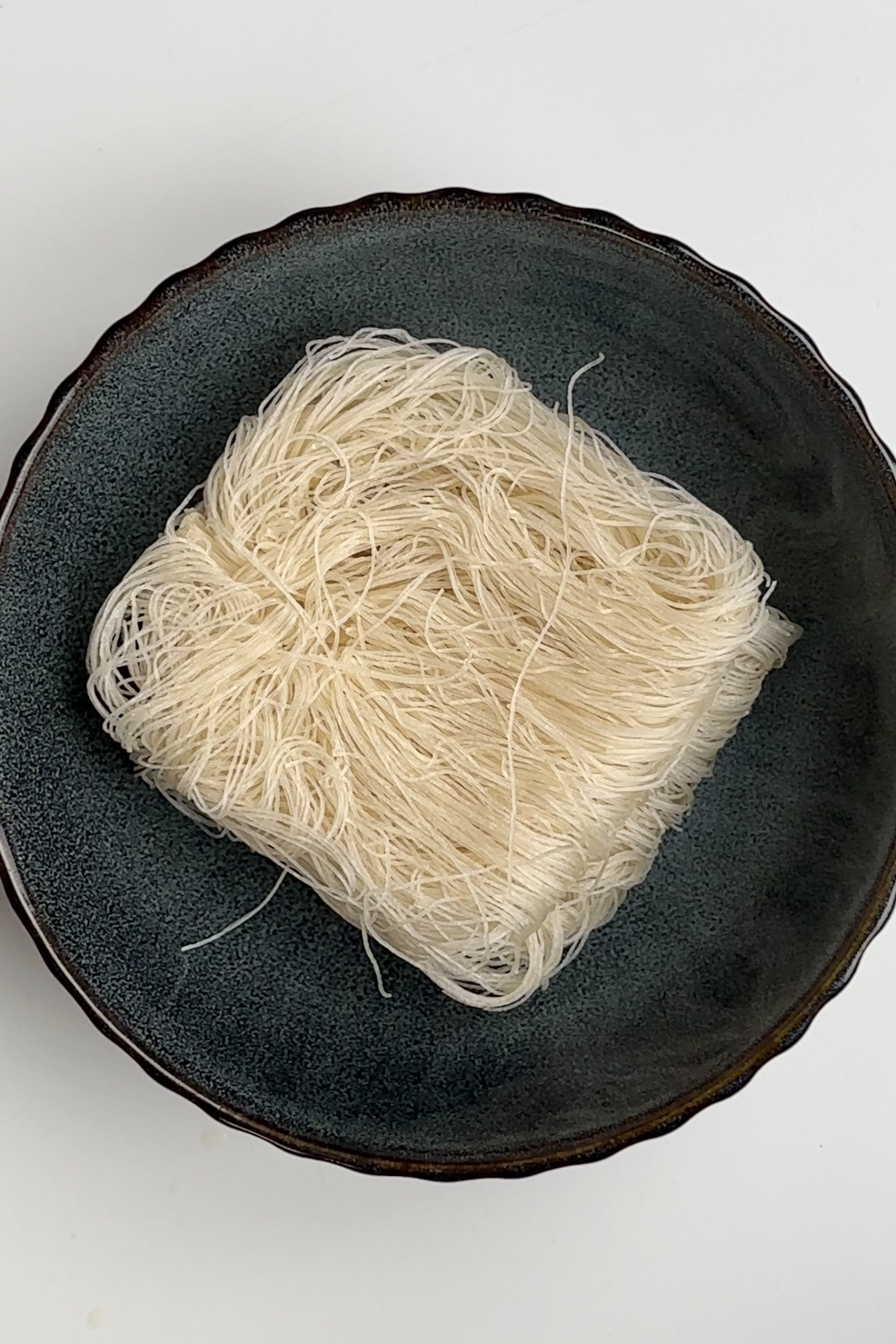Cooking vermicelli rice noodles in a bowl.