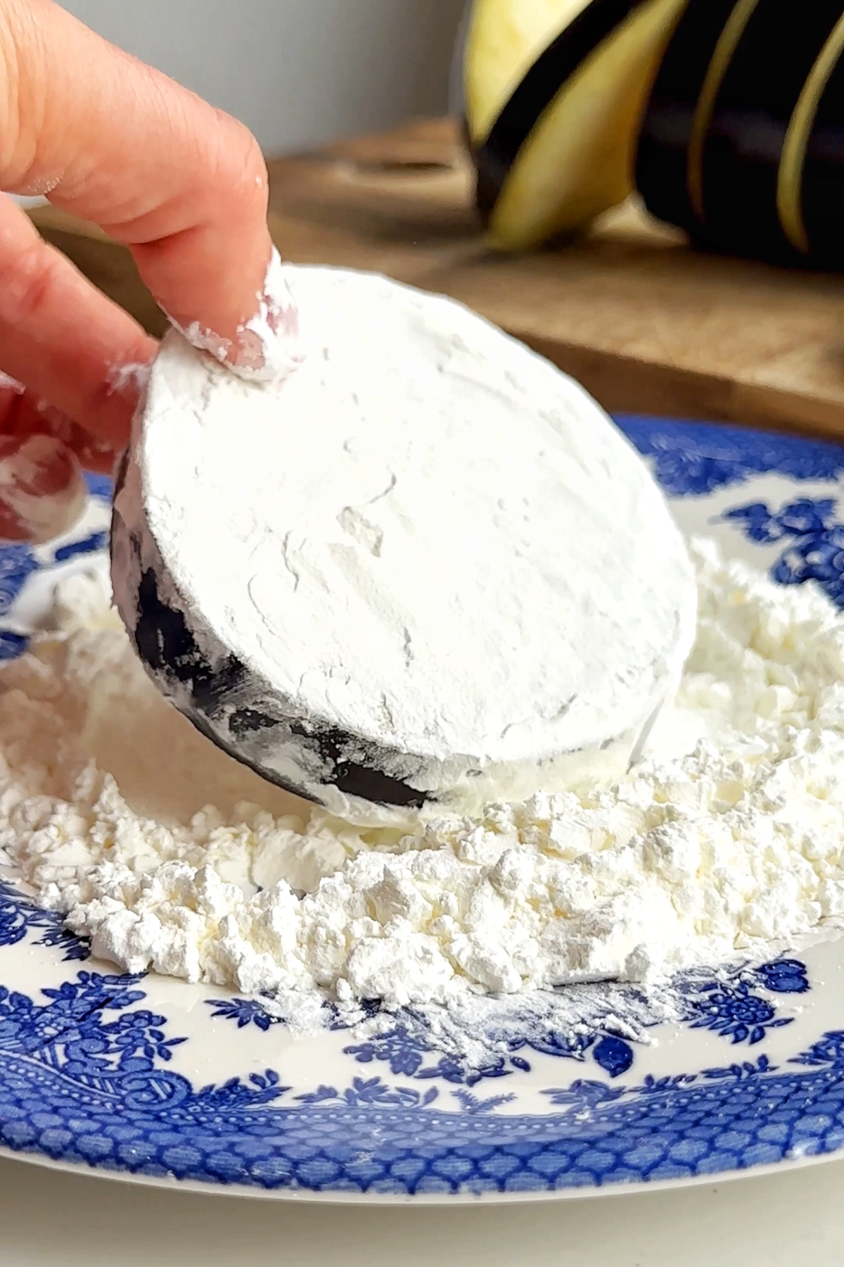 Coating aubergine discs in cornflour.