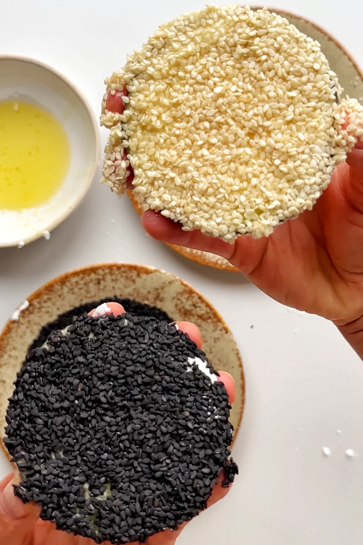 Coating aubergine discs in sesame seeds.
