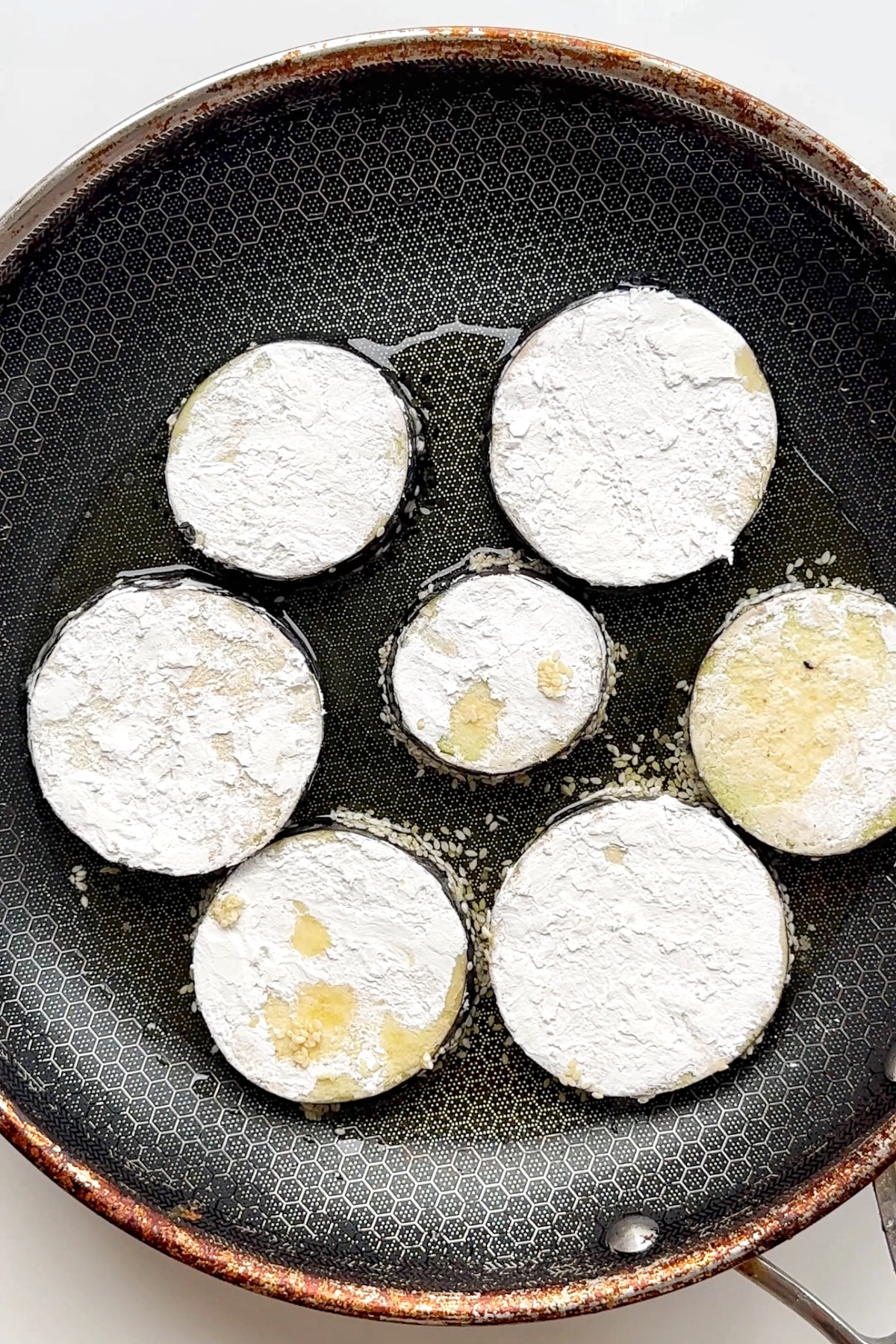 Frying aubergine discs.