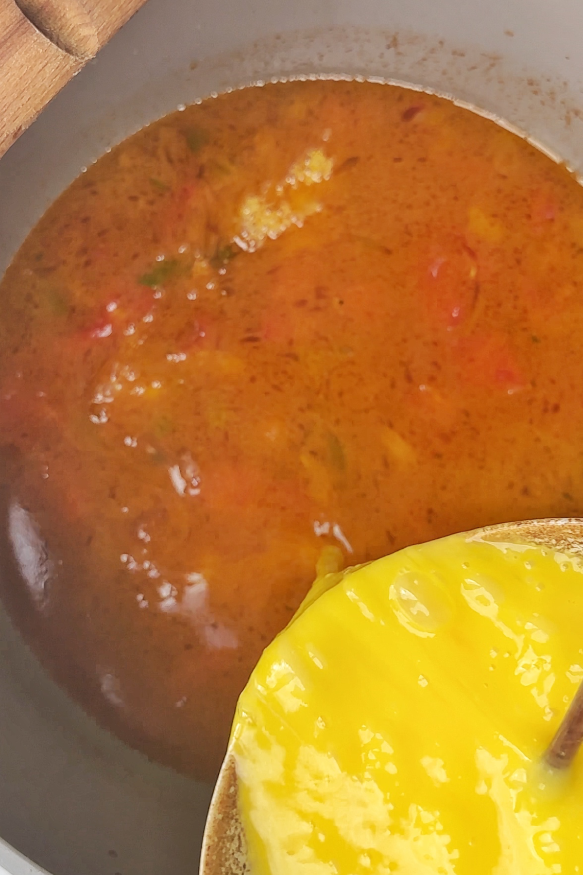 Drizzling in an egg drop mixture into tomato soup.