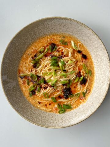Bowl of noodles with tomato and egg drop.