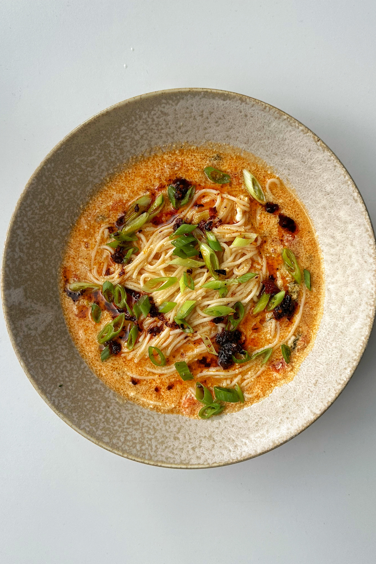 Bowl of noodles with tomato and egg drop.