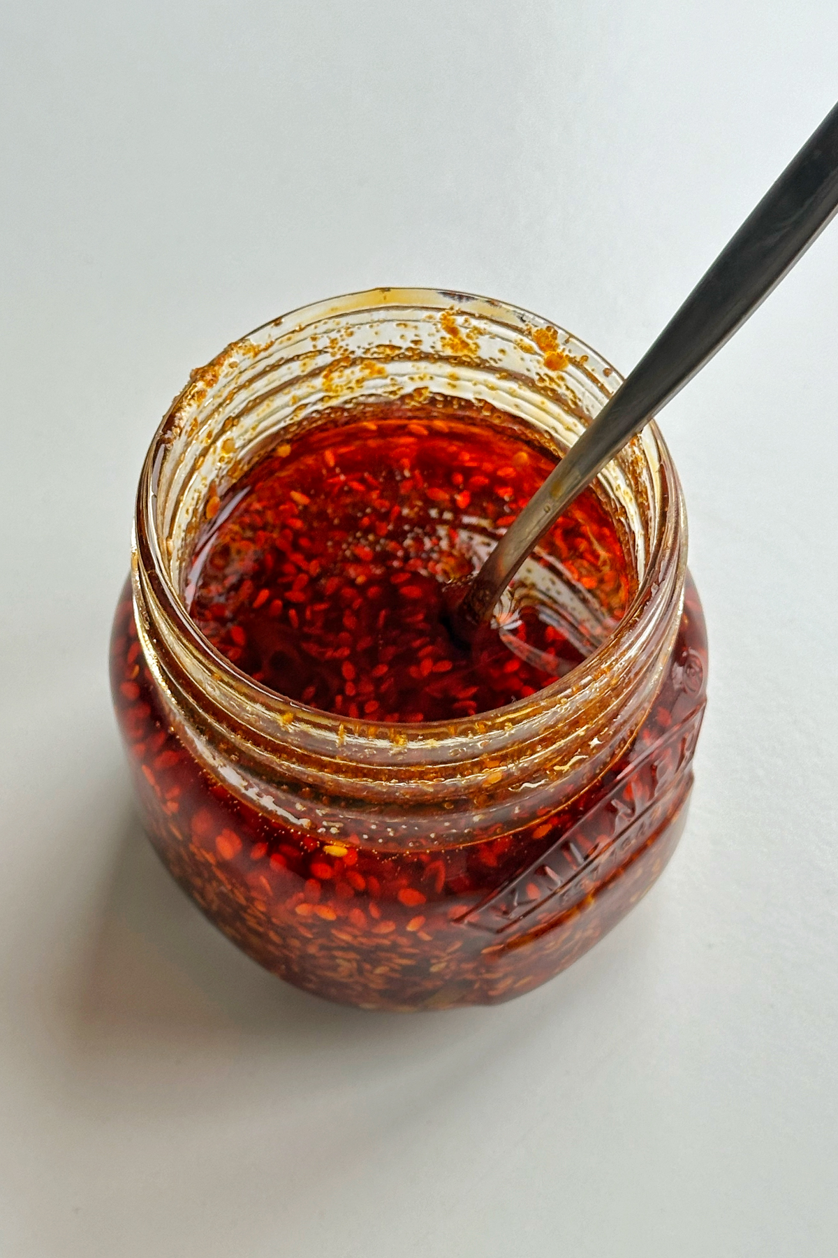 Glass jar with chilli oil in it.