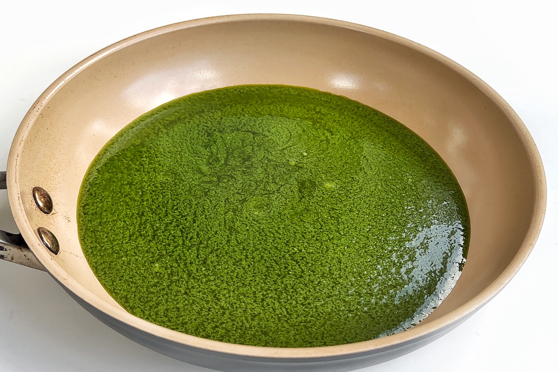 Green cilantro sauce in a frying pan.