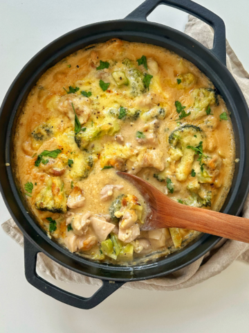 Chicken casserole in a black dish with a wooden spoon.