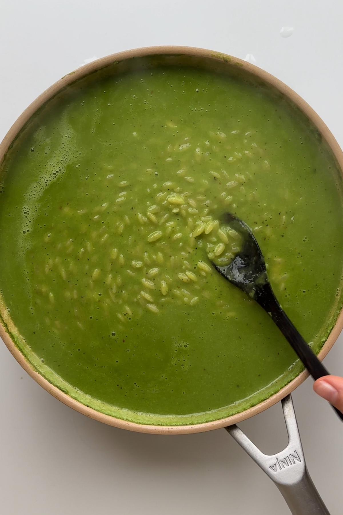 Frying pan with orzo and green sauce.