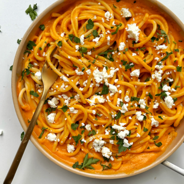 Pasta sauce sweet potato in a pan with feta cheese and parsley.