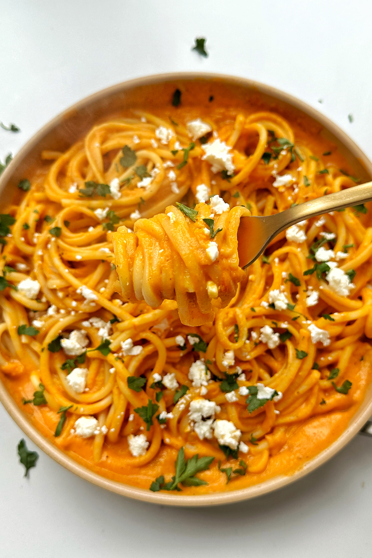 Picking up sweet potato pasta sauce with a fork.