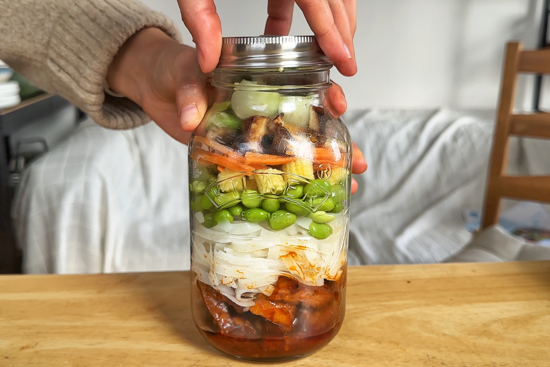 Mason jar with tofu, noodles, and vegetables.