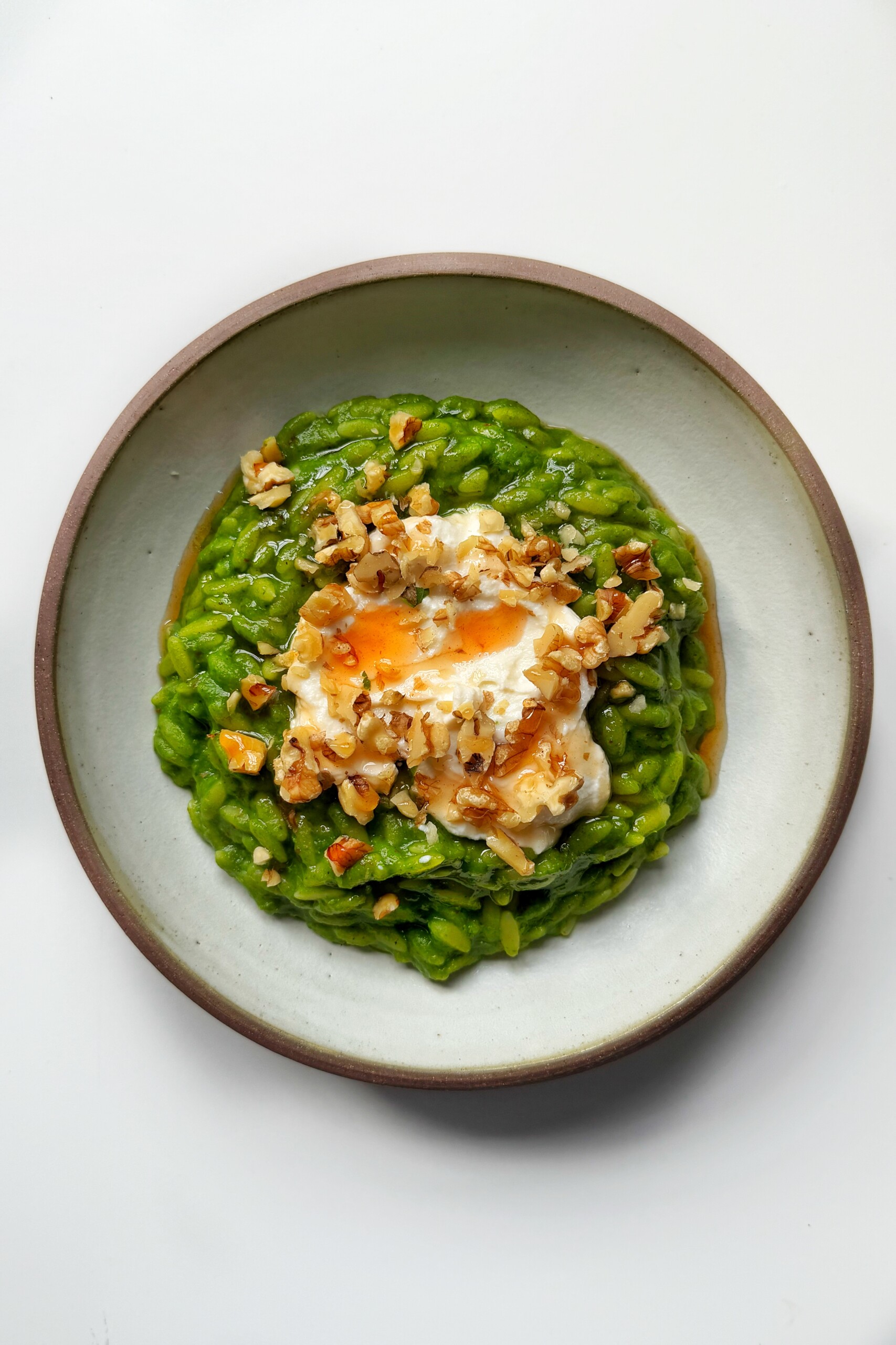green orzo topped with whipped ricotta and hazelnuts and hot honey.