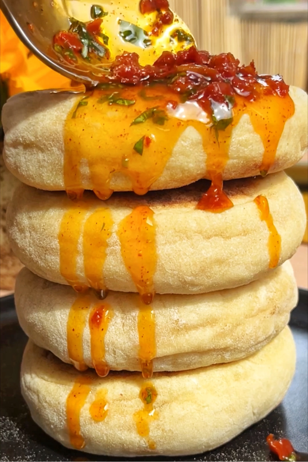 Stuffed flatbreads with a basil sun-dried tomato oil being drizzled over them.