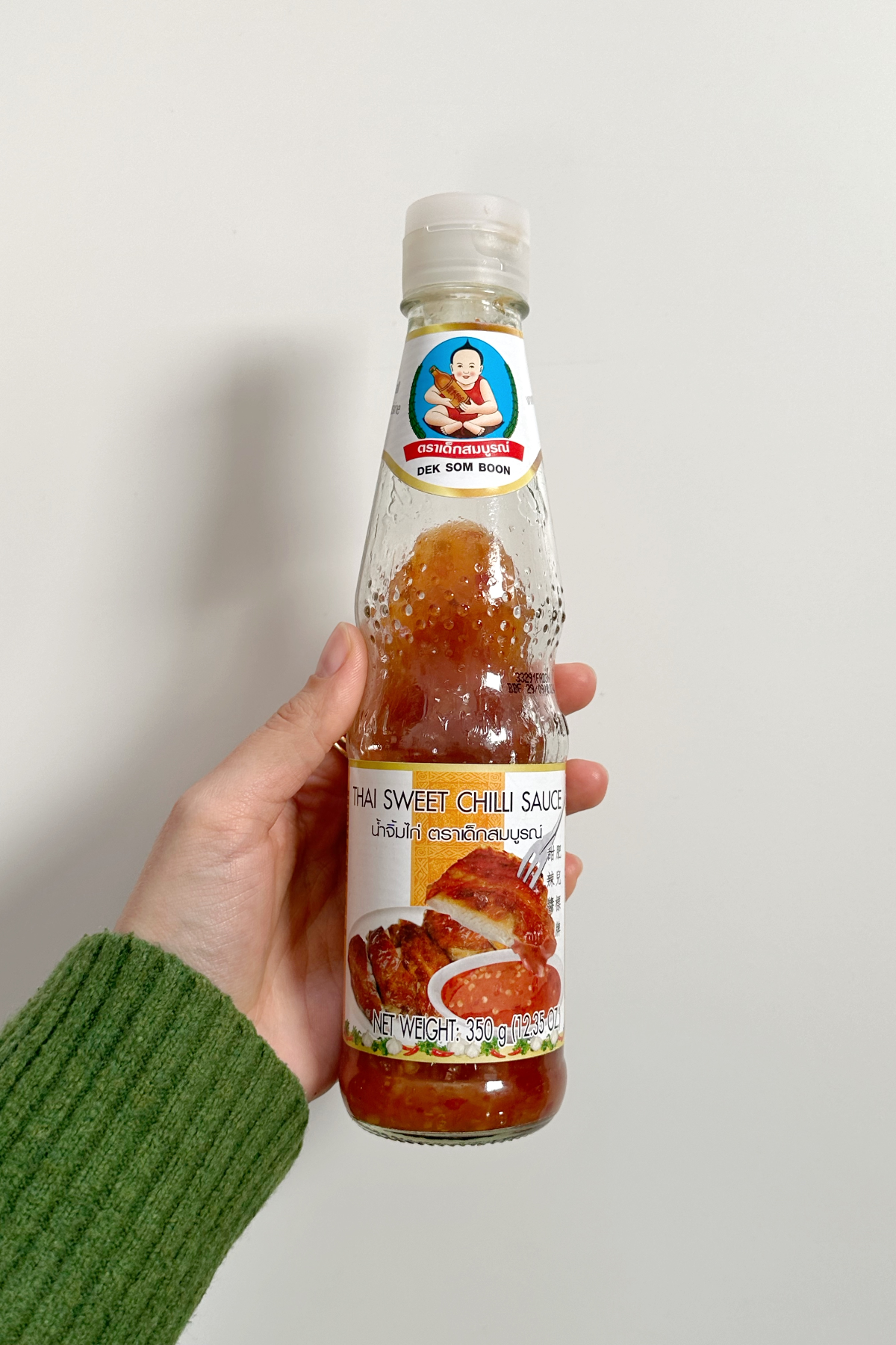 Sweet chilli sauce being held.