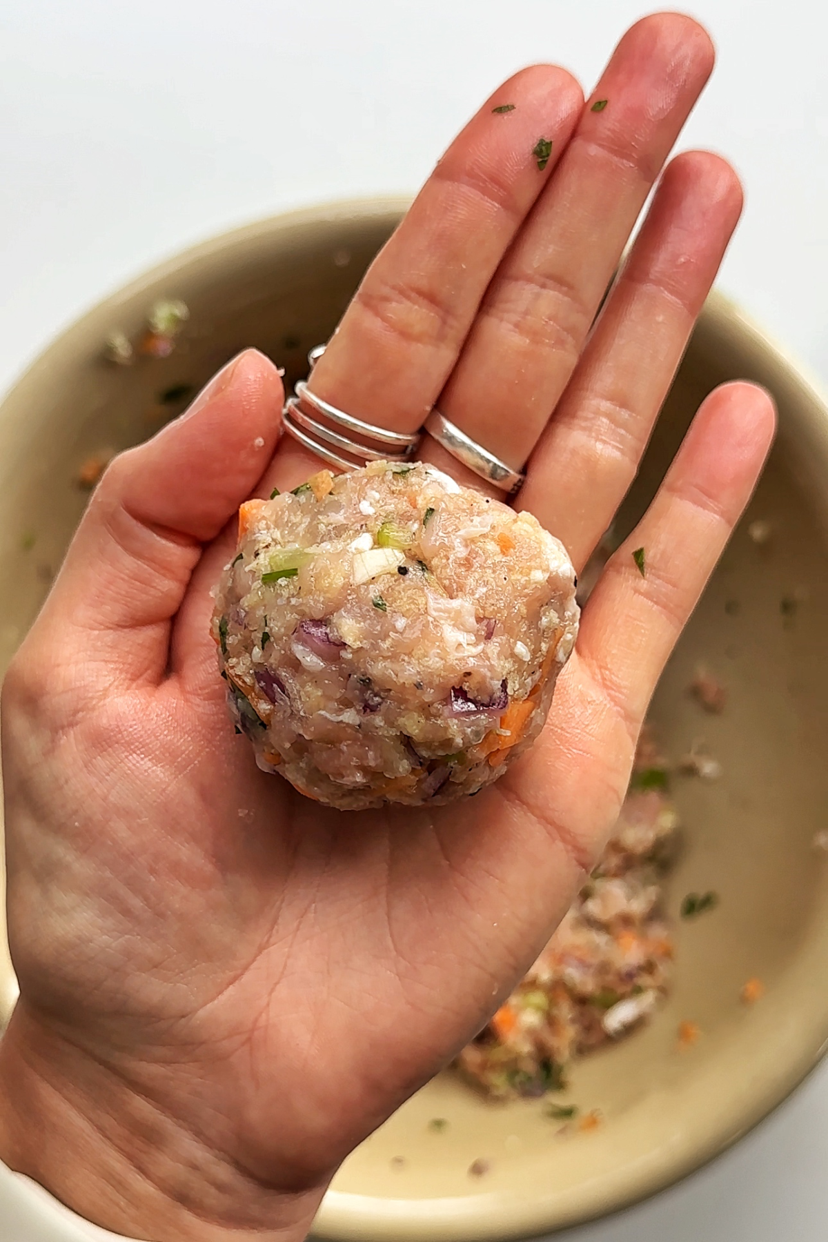 Rolling chicken meatballs into balls about the size of a golf ball.