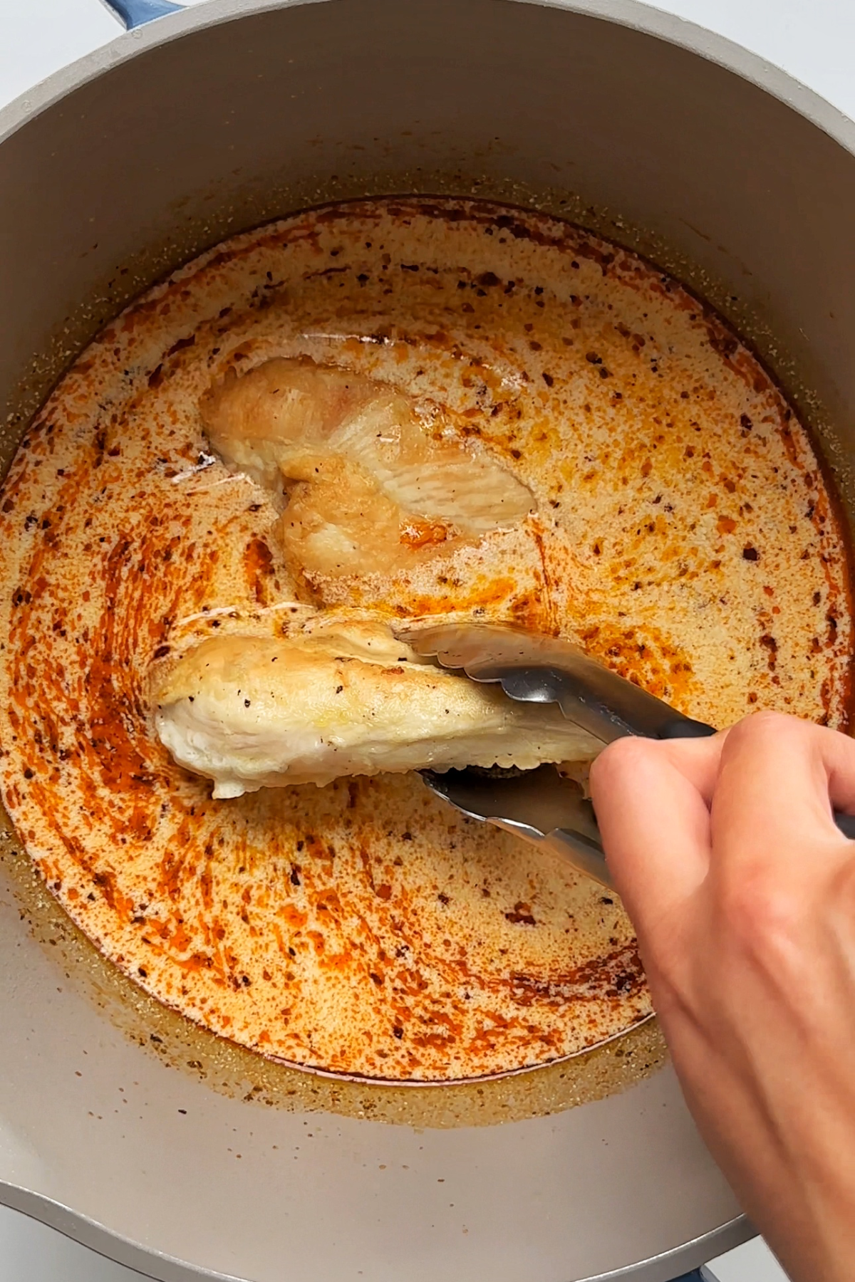 Adding chicken breast into a lemon chicken ramen broth. 